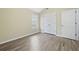 Spacious bedroom featuring wood-look floors and double doors at 6207 Willowbrook Dr, Riverdale, GA 30296