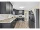 Modern kitchen with dark cabinets, granite counters, and stainless steel appliances at 6207 Willowbrook Dr, Riverdale, GA 30296