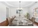 Virtually staged dining room with hardwood floors and chandelier at 4302 Maclaren Ct, Powder Springs, GA 30127