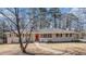 Brick ranch house with red door, walkway, and mature trees at 475 Shannon Way, Lawrenceville, GA 30044