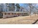 Brick ranch house with a red door and landscaped yard at 475 Shannon Way, Lawrenceville, GA 30044