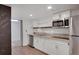 Small basement kitchen with white cabinets, granite counters, and stainless steel appliances at 2530 Ashbourne Dr, Lawrenceville, GA 30043