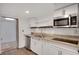 Small basement kitchen with white cabinets, granite counters, and stainless steel appliances at 2530 Ashbourne Dr, Lawrenceville, GA 30043