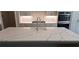 Island sink detail in a modern kitchen with white countertops and backsplash at 4525 Aiden Way, Cumming, GA 30041
