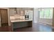 Modern kitchen featuring an island with seating, stainless steel appliances, and natural light from the large window at 4525 Aiden Way, Cumming, GA 30041
