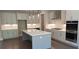 Bright kitchen with white cabinets, stainless steel appliances, island with marble countertop, and hardwood flooring at 4525 Aiden Way, Cumming, GA 30041