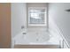 Bathroom with soaking tub, window, and neutral color palette at 7110 Ravenwood Ln, Lithonia, GA 30038