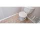 Clean and simple toilet and tile floor in this small bathroom at 7110 Ravenwood Ln, Lithonia, GA 30038
