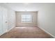 Simple bedroom with neutral walls, carpet and window at 7110 Ravenwood Ln, Lithonia, GA 30038