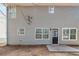 Gray house exterior with multiple windows and a back door leading to a small patio at 7110 Ravenwood Ln, Lithonia, GA 30038