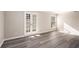 Bright living room featuring gray vinyl flooring and french doors at 175 Rue Fontaine, Lithonia, GA 30038