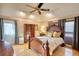 Cozy bedroom featuring a decorative ceiling fan, wood floors, and a door to the outside at 3411 Deer Sw Trce, Conyers, GA 30094