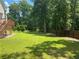 Large grassy backyard with wooden fence and mature trees at 1886 Clay Sw Dr, Marietta, GA 30064