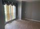 Bedroom featuring a large window with decorative curtains, plush carpeting, and neutral color scheme at 1886 Clay Sw Dr, Marietta, GA 30064