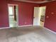 Spacious bedroom featuring neutral carpeting and doors to bathroom and hallway at 1886 Clay Sw Dr, Marietta, GA 30064