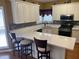 Bright kitchen featuring white cabinets, barstool seating, and quartz countertops at 1886 Clay Sw Dr, Marietta, GA 30064