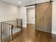 Upper hallway with barn door and ornate metal railing at 571 Glen Eagles Se Cir, Marietta, GA 30067
