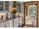 Charming wet bar with stone backsplash, glass front cabinets and wine cooler located off the living room at 571 Glen Eagles Se Cir, Marietta, GA 30067