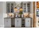 Charming wet bar featuring stone backsplash, glass front cabinets, wine cooler, and stainless steel beverage center at 571 Glen Eagles Se Cir, Marietta, GA 30067