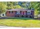 Brick ranch house with a well-manicured lawn and American flag at 156 Main St, Lilburn, GA 30047