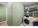 Laundry room with washer, dryer, and shelving for storage at 156 Main St, Lilburn, GA 30047