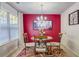 Cozy dining area with red accent wall, modern chandelier, and bright natural light at 177 Oakland Hills Way, Lawrenceville, GA 30044