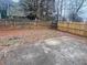 Private backyard features a wooden fence and a concrete patio for outdoor enjoyment at 2800 Camelot Woods Dr, Lawrenceville, GA 30044