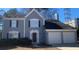 Two-story house with gray siding, two-car garage, and landscaping at 3730 Oak Park Dr, Suwanee, GA 30024