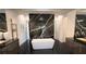 Modern bathroom with freestanding tub, striking marble wall, and contemporary fixtures at 6711 Bishop Rd, Fairburn, GA 30213