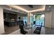 Elegant dining area featuring a glass table, modern chandelier, and scenic backyard view at 6711 Bishop Rd, Fairburn, GA 30213