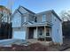 Two-story house with gray siding and brick accents, attached garage, and covered porch at 566 Abbott Se Ct, Atlanta, GA 30354