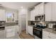 Modern kitchen with white cabinets, granite countertops, and stainless steel appliances at 566 Abbott Se Ct, Atlanta, GA 30354