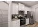 Modern kitchen with white cabinets, granite counters, and stainless steel appliances at 566 Abbott Se Ct, Atlanta, GA 30354