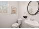 Small powder room with white pedestal sink, toilet and decorative mirror at 566 Abbott Se Ct, Atlanta, GA 30354