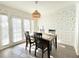 Bright dining room featuring a wooden table, stylish wallpaper, and a wicker pendant light at 6980 Roswell Rd # E1, Sandy Springs, GA 30328