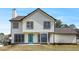 Exterior rear view of house showing backyard, lower patio, and blue rear entry door at 125 Cinnamon Fern Cir, Covington, GA 30016