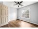 Bedroom with wood floors, large window and ceiling fan at 125 Cinnamon Fern Cir, Covington, GA 30016