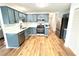 Kitchen with blue cabinets, quartz countertops, and stainless steel appliances at 125 Cinnamon Fern Cir, Covington, GA 30016