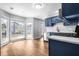 Bright kitchen area with large window, wood floors, stainless appliances and blue cabinets at 125 Cinnamon Fern Cir, Covington, GA 30016