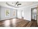 Spacious main bedroom featuring hardwood floors, a tray ceiling with ceiling fan, and two windows at 125 Cinnamon Fern Cir, Covington, GA 30016