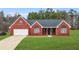 Brick ranch house with gray roof, large windows, and a two-car garage at 435 Berkshire Dr, Covington, GA 30016