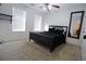 Neutral bedroom with plush carpet, a large mirror and natural light from the two windows at 553 Stonemill Mnr, Lithonia, GA 30058