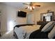 Well-lit bedroom with soft carpet, decorative accents, a ceiling fan, and access to the hallway at 553 Stonemill Mnr, Lithonia, GA 30058