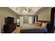 Spacious main bedroom featuring a tray ceiling, ceiling fan, and a dark wood dresser with a TV at 553 Stonemill Mnr, Lithonia, GA 30058