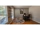 Bright home office with ample natural light, hardwood floors, and a unique industrial-style shelving unit at 553 Stonemill Mnr, Lithonia, GA 30058