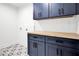 Laundry room with blue cabinets, wood countertop, and patterned tile floor at 350 Jayne Ellen Way, Alpharetta, GA 30009