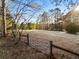 Metal gate opens to a large grassy field, surrounded by mature trees at 1921 W Hightower W Trl, Conyers, GA 30012