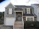 Gray two-story house with a white garage door and wooden steps at 390 Lakeridge Ct, Riverdale, GA 30274