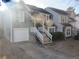 Gray townhome with white garage door and wooden stairs leading to the entrance at 390 Lakeridge Ct, Riverdale, GA 30274