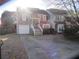 Townhouse with gray siding, white garage door, and a brick accent wall at 390 Lakeridge Ct, Riverdale, GA 30274